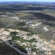 Vue aérienne d'un monticule de pegmatite et du lac Kapisikama en lien avec le projet de mine de lithium Baie-James.