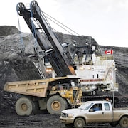 Une pelle minière remplit un camion de transport dans une mine de sables bitumineux près de Fort McMurray, en Alberta.