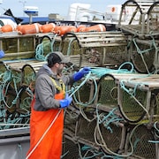 Un pêcheur attache ses cordages aux casiers.
