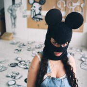 MissMe regarde la caméra, le visage caché par son masque de Minnie Mouse.