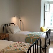 Deux lits simples dans une chambre avec une grande fenêtre 