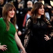 Les deux femmes habillées d'une robe verte et noire sourient.