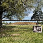 Derrière une clôture en métal, une montagne de gravats se dresse sur l'un des parcours de neuf trous du club de golf du parc East Potomac, à Washington, le 12 avril 2026.