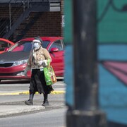 Une femme masquée marche dans l'arrondissement de Montréal-Nord.