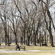 Une femme mange dans un parc de Montréal par une chaude journée de printemps à Montréal, le jeudi 25 mars 2021.