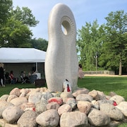 Une pierre percée aux airs sépulcraux dans un parc. 