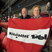 Des gens dans les gradins montrant leur drapeau d'une ville d'Autriche.