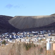 Des maisons à Murdochville l'automne devant la montagne de résidus miniers.