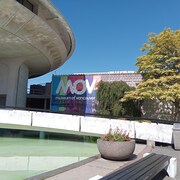 Façade du Musée de Vancouver avec un bassin d'eau et une bannière indiquant MOV Museum of Vancouver.