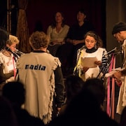 Un extrait du spectacle « A Casual Reconstruction », réunissant sur scène des membres du public. En arrière-plan, Johanne Nutter et Nadia Myre.