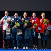 Des membres de l'équipe canadienne de natation artistique avec une médaille au cou.
