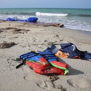 Des gilets de sauvetage échoués sur une plage.