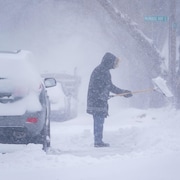 Une personne pellette de la neige à Saskatoon, Saskatchewan. Environnement Canada a émis un avertissement de tempête hivernale pour Saskatoon alors qu'un clipper albertain traverse les Prairies. Le 26 février 2024.