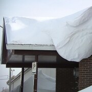 Un gros amas de neige sur un pignon de l'aréna Guy-Carbonneau, à Sept-Îles.