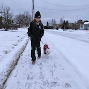 Une femme fait prendre uen marche à un chien. 