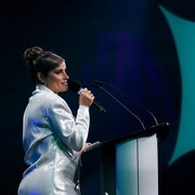 La chanteuse Nelly Furtado lors de l'annonce des nominés des Junos à Toronto. Elle parle dans un micro. 