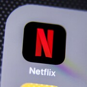 Une photo d'un écran de téléphone montrant l'icône de l'application Netflix : la lettre « N » rouge sur fond noir.
