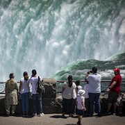 Des touristes prennent des photos des chutes Niagara.