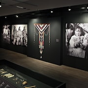 L'oeuvre Piqutiapiit, faite de tissus, de cuir, de bois et de perles colorées, avec des portraits de femmes inuit autour. 