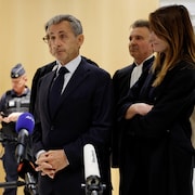 Nicolas Sarkozy s'adresse aux journalistes à la sortie du tribunal, accompagné de sa femme Carla Bruni et de ses avocats.