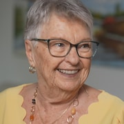 Nicole Pilon sourit en regardant au loin. Elle se trouve dans son logement.