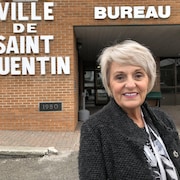 Une dame devant l’hôtel de ville de Saint-Quentin, au Nouveau-Brunswick.