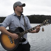 Un jeune homme joue de la guitare.