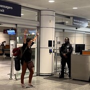 Une femme fait le V de la victoire &agrave; l'a&eacute;roport de Montr&eacute;al.