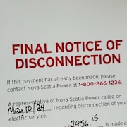 Une note de Nova Scotia Power indiquant qu' à défaut d'un paiement l'électricité sera coupée.
