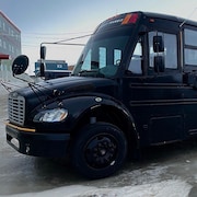 Un autobus peint en noir est stationné sur une rue glacée à Iqaluit, au Nunavut, en avril.2024.
