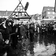 Olaf Scholz au milieu d'une foule, les pieds dans l'eau.