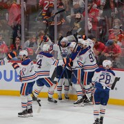 Des joueurs de hockey célèbrent un but.