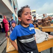 Un enfant pleure près d'une école.