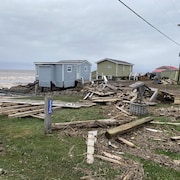 Des maisons sur le bord de l'eau. Tout le secteur est jonché de bois et de débris amenés par l'ouragan. Un trottoir de bois est à moitié détruit.