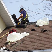 Un ouvrier travaille sur un toit.