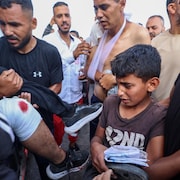 Des secouristes palestiniens transportent un blessé dans une ambulance.