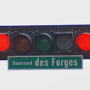 Un feu de circulation sous lequel est indiqué Boulevard des Forges.