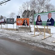 De droite à gauche, des panneaux électoraux de Karla Bernard, Michelle Neill, Sandra Sunil et Rob Lantz.