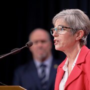La ministre Selina Robinson avec le premier ministre John Horgan en arrière-plan. 
