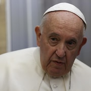 Portrait du pape François à bord d'un avion.