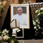 Un portrait du pape est affiché dans une église.