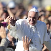 Le pape François prend un bain de foule et salue des croyants.