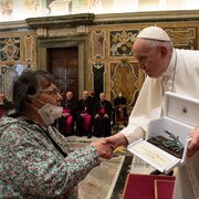 Le pape François serre la main d'une femme faisant partie de la délégation autochtone le 1er avril 2022.