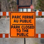 Une pancarte orange annonce ''parc fermé au public'' en Français et en Anglais.