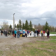 Une quarantaine de personnes sont réunies à l'extérieur devant les installations du parc de planche à roulettes.