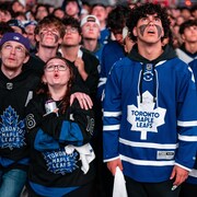 Des partisans réunis à l'extérieur de l'aréna Banque Scotia suivent le match au cours duquel les Maple Leafs ont été éliminés dimanche. 
