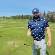 Pascal Gagnon tient un morceau de gazon arraché d'un terrain de golf.