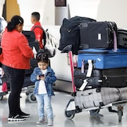 Des passagers avec leurs bagages à l'aéroport Pearson de Toronto.