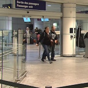 Des gens sortent par la sortie des passagers à l'aéroport Montréal-Trudeau.