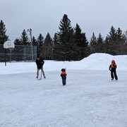 Trois personnes sur une patinoire.
